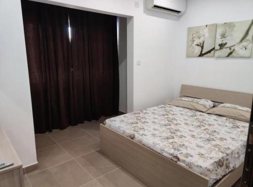 a bedroom with a bed and a large window at 4 bedroom apt 5 mins away from beach and amenities in St. Paul's Bay
