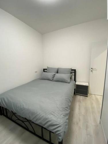 a bed in a white room with a mirror at Apartment in Yerevan in Yerevan