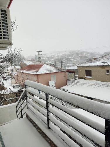 a snow covered balcony with buildings and roofs at Stavroula's Houses in Kélla
