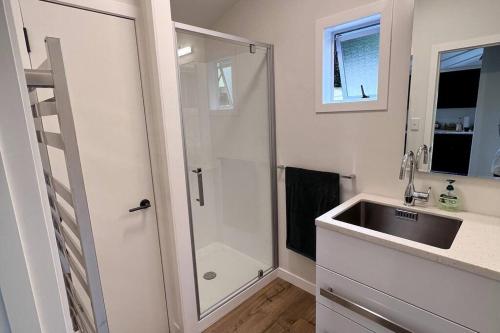 a bathroom with a shower and a sink at The Lake House at Waikaremoana in Tuai