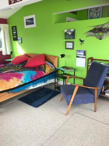 a bedroom with a bed and a green wall at Piringa in Dunedin