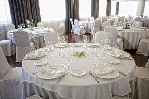 a dining room with white tables and white chairs at Hotel Almirante in Ferrol