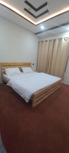 ein Schlafzimmer mit einem großen Bett mit weißer Bettwäsche in der Unterkunft The Himalayan Guest House in Skardu