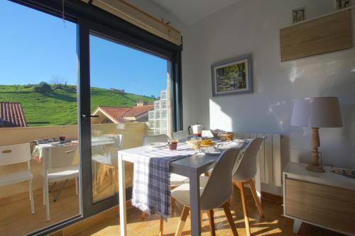 ein Esszimmer mit einem Tisch und einem großen Fenster in der Unterkunft Rozando el mar en puerto calderon in Santillana del Mar