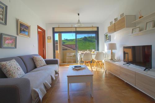 ein Wohnzimmer mit einem Sofa und einem TV in der Unterkunft Rozando el mar en puerto calderon in Santillana del Mar