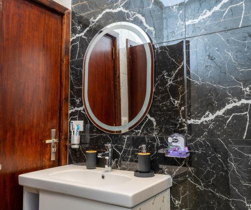 a bathroom with a sink and a mirror at Premium apartment in new cairo in Cairo