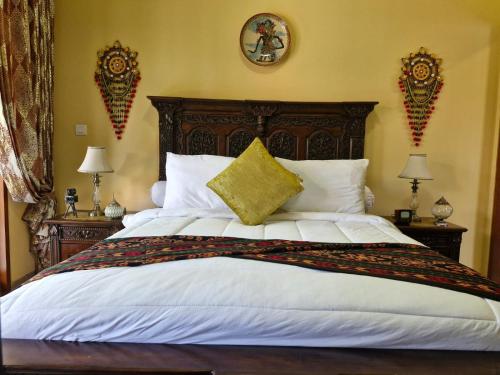 a bedroom with a large bed with a wooden headboard at Sari Ayuning Nusa Guest House in Nusa Lembongan