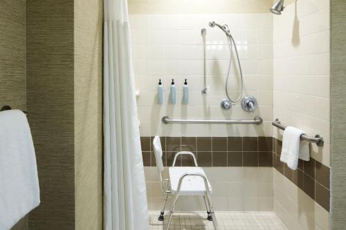 a shower with a chair in a bathroom at Courtyard Charleston Mount Pleasant in Charleston