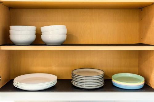 four bowls and plates are sitting on a shelf at Palm Wave Says - 5 min to Best Locations in West Palm Beach