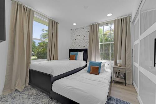 a bedroom with two beds and a window at Palm Wave Says - 5 min to Best Locations in West Palm Beach