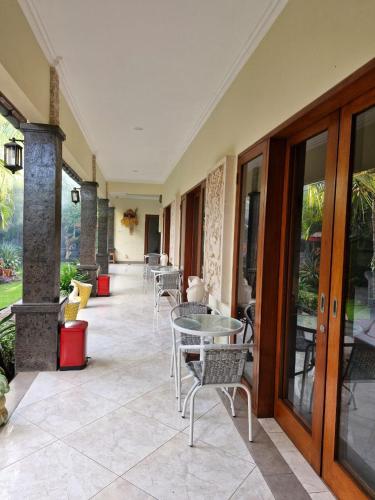 a patio with tables and chairs in a building at Sari Ayuning Nusa Guest House in Nusa Lembongan