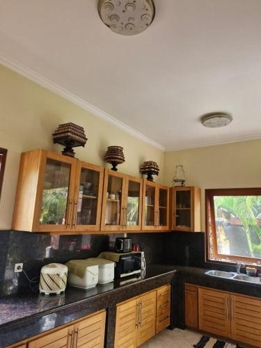 a kitchen with wooden cabinets and a counter top at Sari Ayuning Nusa Guest House in Nusa Lembongan
