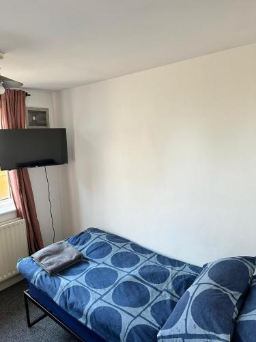 a bedroom with a bed with a blue comforter at Wembley property in London