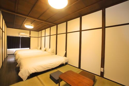 a bedroom with two beds and a table at Yagara Terrace House A in Osaka