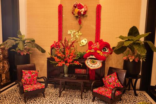 Habitación con sillas, máscara y flores en Thuy Duong Boutique Hotel Hue, en Hue