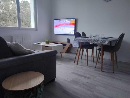a living room with a couch and a table at L'Appartement du Veillon in Talmont