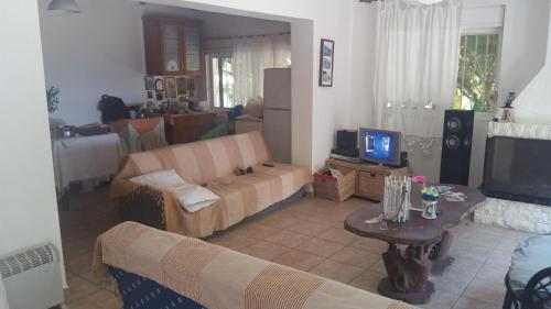 a living room with a couch and a tv at House on the beach in Niforeika