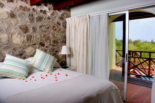 a bedroom with a bed with red roses on it at Bright & Beautiful 2 Bedroom Villa in Cap Estate