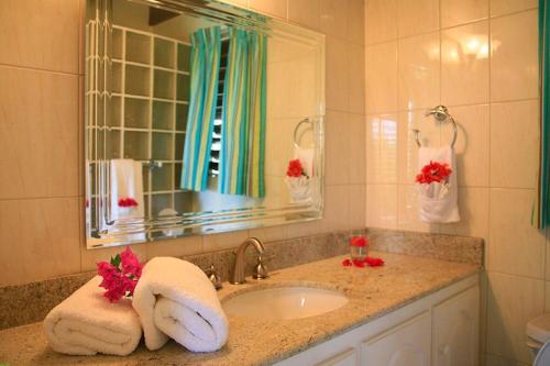 W łazience znajduje się umywalka, lustro i ręczniki. w obiekcie Bright & Beautiful 2 Bedroom Villa w mieście Cap Estate