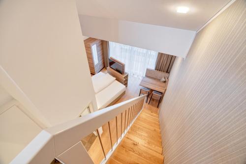 a room with a staircase with a couch and a chair at WESTSIDE Hotel in Munich
