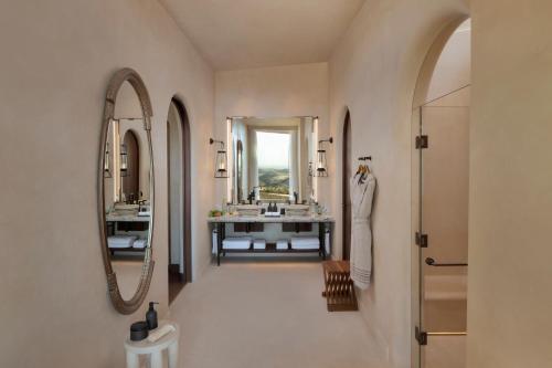a bathroom with two sinks and two mirrors at Six Senses Southern Dunes, The Red Sea in Khuff