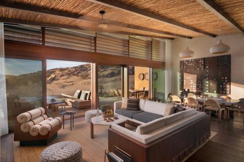 a living room with couches and a dining room at Six Senses Southern Dunes, The Red Sea in Khuff