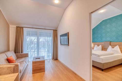 a living room with a couch and a mirror at WESTSIDE Hotel in Munich