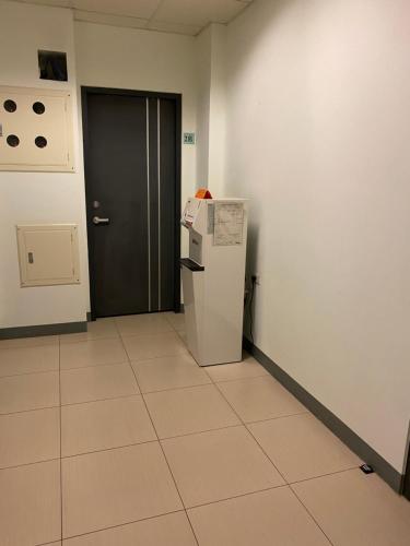 an empty room with a refrigerator and a door at KSF B&B in Tainan