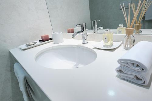 y baño con lavabo blanco y espejo. en Hotel Des Bains Terme, en Montegrotto Terme