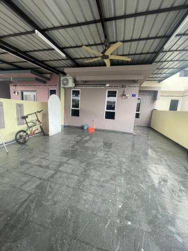an empty room with a bike and a ceiling at Amir Homestay in Yong Peng