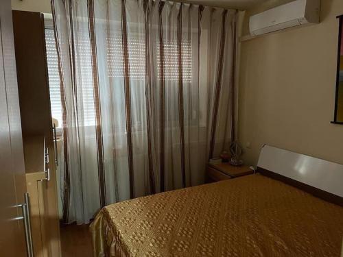 a bedroom with a bed and a window with curtains at Apartament cu un dormitor / One bedroom apartment in Satu Mare