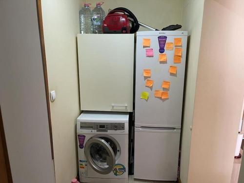 a refrigerator with papers on it next to a washing machine at Apartament cu un dormitor / One bedroom apartment in Satu Mare