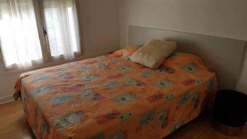 łóżko z pomarańczową kołdrą w sypialni w obiekcie Le Petit HERMITAGE w mieście Massiac