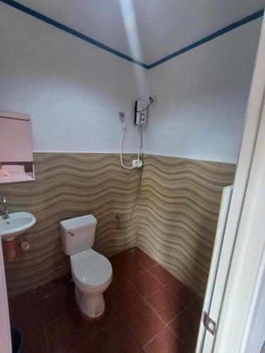 a bathroom with a toilet and a sink at LOKI'S APARTMENT in Catarman