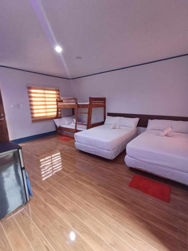 a room with two beds and a tv in it at LOKI'S APARTMENT in Catarman