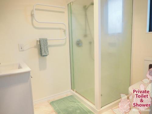 een douche met een glazen deur in de badkamer bij Accommodations Homestay in Rototuna, Hamilton in Hamilton