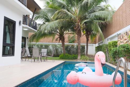 a swimming pool with a pink inflatable swan in a house at WangTanChiangMai PoolVilla精品泳池别墅 in Chiang Mai