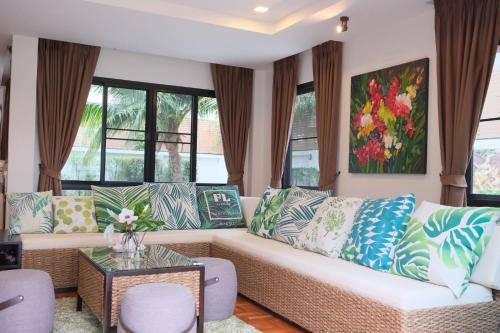 a living room with a couch and some windows at WangTanChiangMai PoolVilla精品泳池别墅 in Chiang Mai