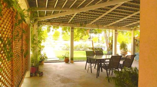 a patio with a table and chairs in a house at חלון לגלבוע צימר בוטיק בעמק המעיינות in Bet Alfa