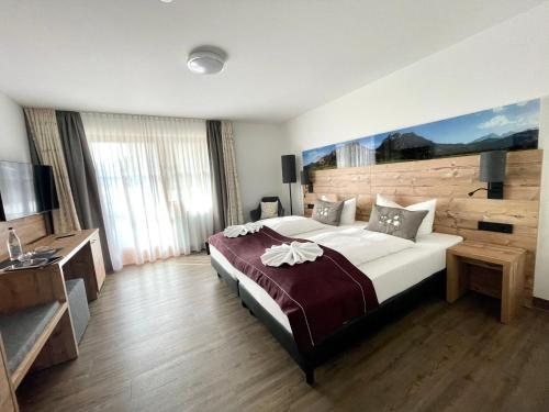 um quarto de hotel com uma cama grande e uma televisão em Gästehaus Seeklause em Schwangau