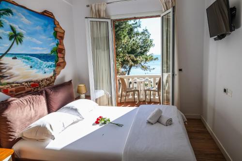a bedroom with a bed and a large window at COSMO Beach Hotel in Durrës
