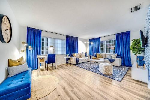 a living room with blue curtains and a blue couch at Stylish - Water View Condo - Palm Wave Says in Coconut Creek