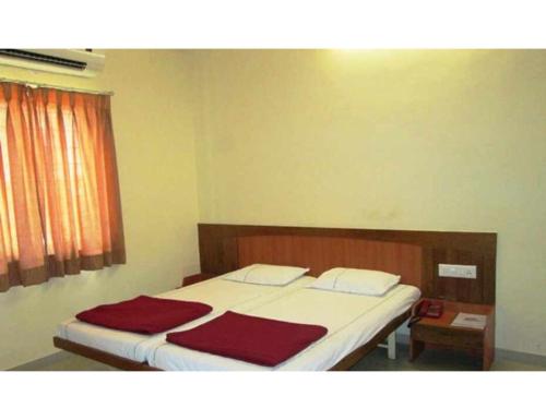 - une chambre avec un lit et une couverture rouge dans l'établissement Hotel Nila Solapur, à Solapur