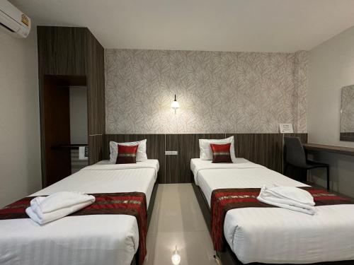 a room with three beds in a hotel room at THE HUB SURATTHANl in Surat Thani