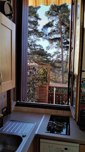 une cuisine avec vue sur un arbre depuis une fenêtre dans l'établissement LA PETITE TOURELLE, à Thorenc