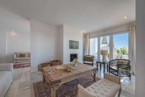 een woonkamer met een houten tafel en een bank bij Selecta - Dream Apartment in Marbella in La Mairena