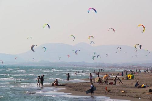 a group of people on a beach flying kites at Apartments Mia Patria in Ulcinj