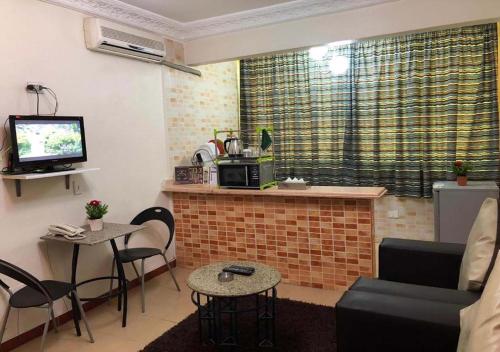 a living room with a fireplace and a tv and chairs at Bonne Vie Studios in 6th Of October