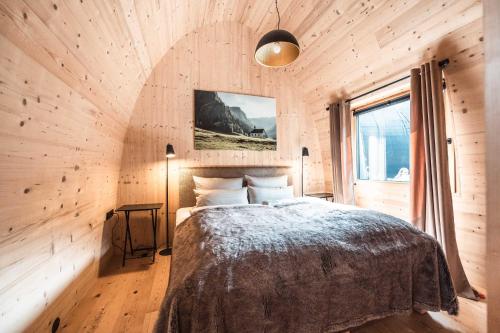 een slaapkamer met een bed in een houten muur bij Himmelchalet - Alpencamping Nenzing in Nenzing