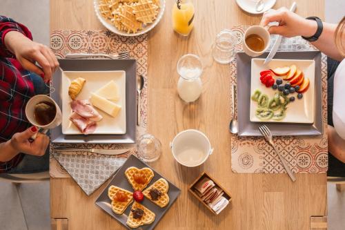 dos personas sentadas en una mesa con platos de comida en B&B Elianto, en Santa Maria Navarrese